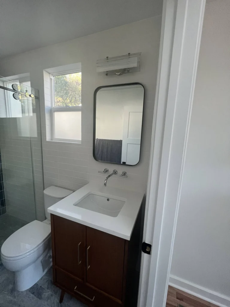 Bathroom remodel: Walnut vanity, wall-mounted faucet and black mirror in an ADU bathroom, Mill Valley
