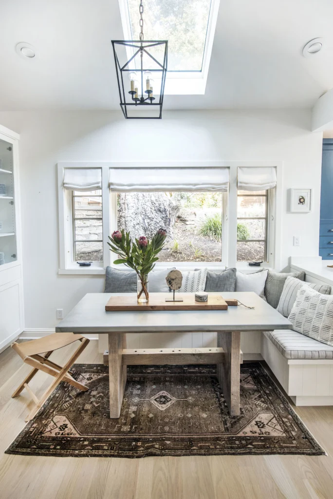 Kitchen remodel: Breakfast nook with built-in banquette, skylight, lantern pendant and three-part window