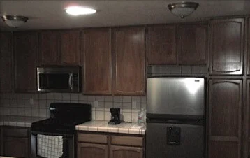 Kitchen remodel: Kitchen before: dark wood cabinets, tiled counters and a black range