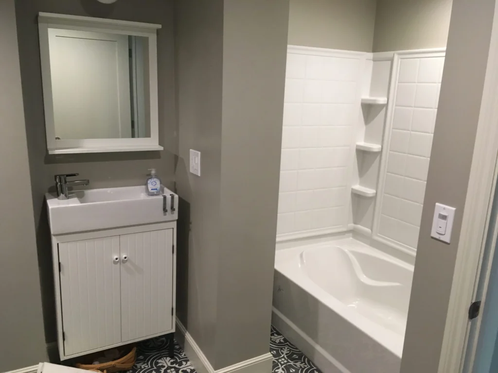 Bathroom remodel: Duplex bathroom with white vanity, new tub surround and patterned floor tile, San Rafael