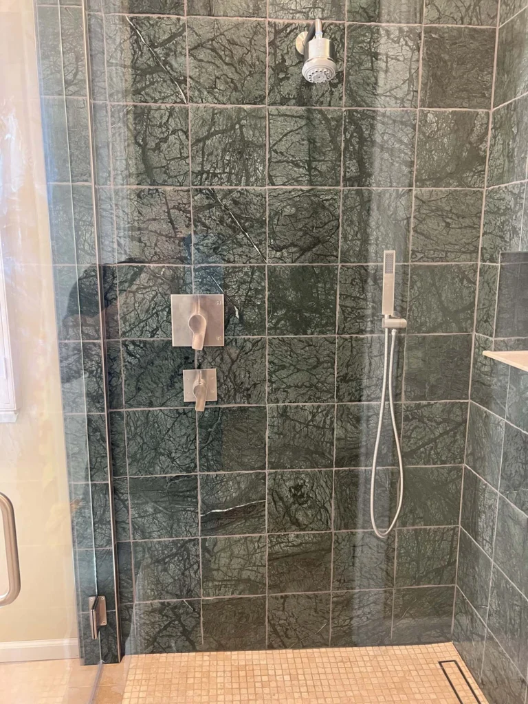 Bathroom remodel: Walk-in shower in green marble with brushed nickel fittings and a mosaic floor, Larkspur