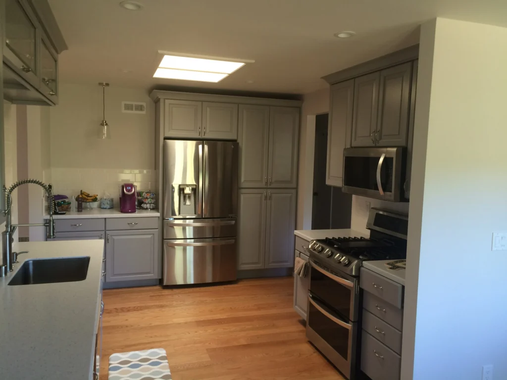 Flooring: Grey kitchen from the island sink: stainless fridge, double oven and oak floor, Novato