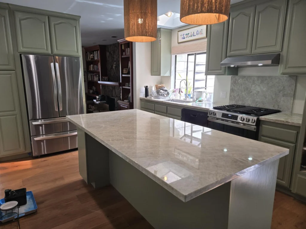 Kitchen remodel: Kitchen remodel with new flooring and utilizing old cabinets to make island. New painted cabinets