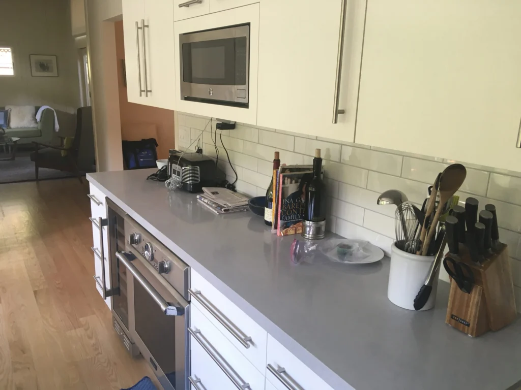 Flooring: White cabinets, wall oven, grey quartz and subway tile over oak floor, Mill Valley