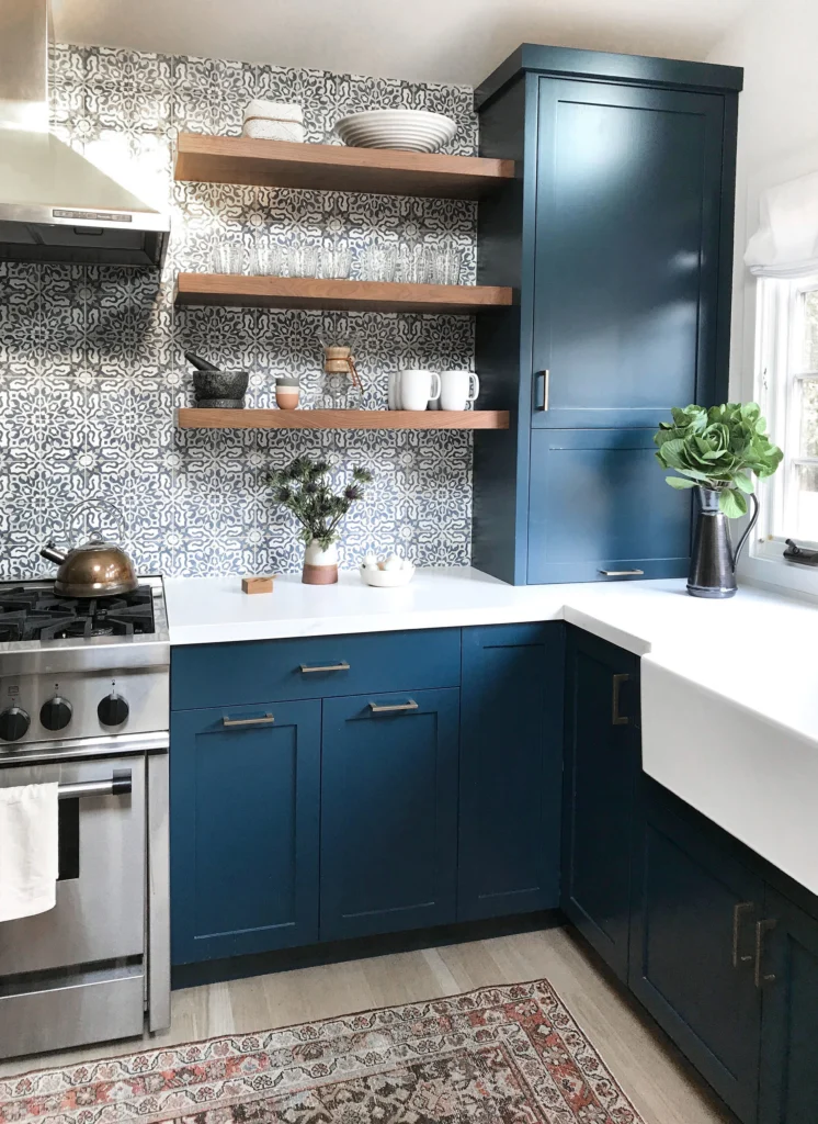 Kitchen remodel: Navy shaker cabinets, white counters, farmhouse sink, patterned cement tile and walnut open shelves