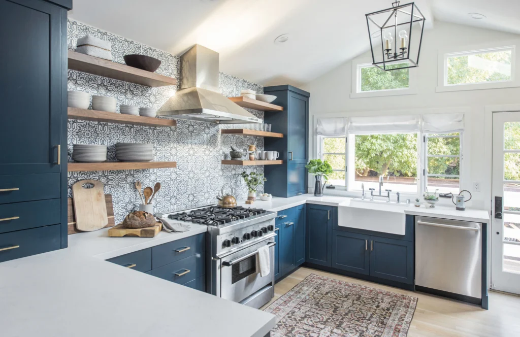Kitchen remodel: Navy shaker kitchen with patterned tile, walnut open shelves, steel range hood and farmhouse sink
