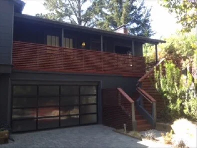 Deck: After: redwood slat deck railing and stairs over a frosted glass garage door