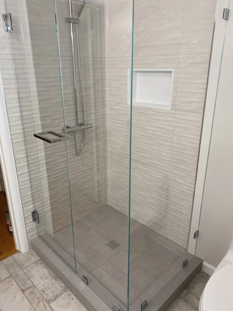 Bathroom remodel: Frameless glass shower in textured tile with a niche and tiled curb, Tiburon