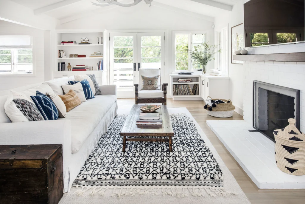 Whole-house remodel: Bright living room with vaulted ceiling, painted brick fireplace, built-in shelves and French doors