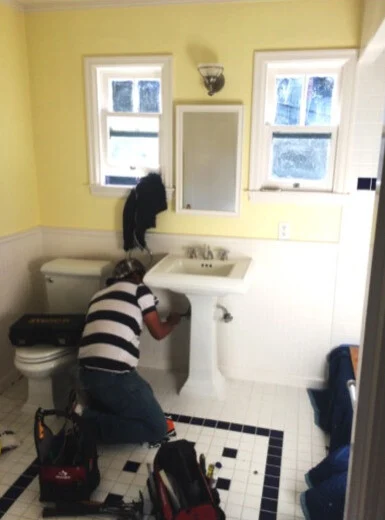 Bathroom remodel: Yellow bathroom before the remodel, with the old fixtures being taken out